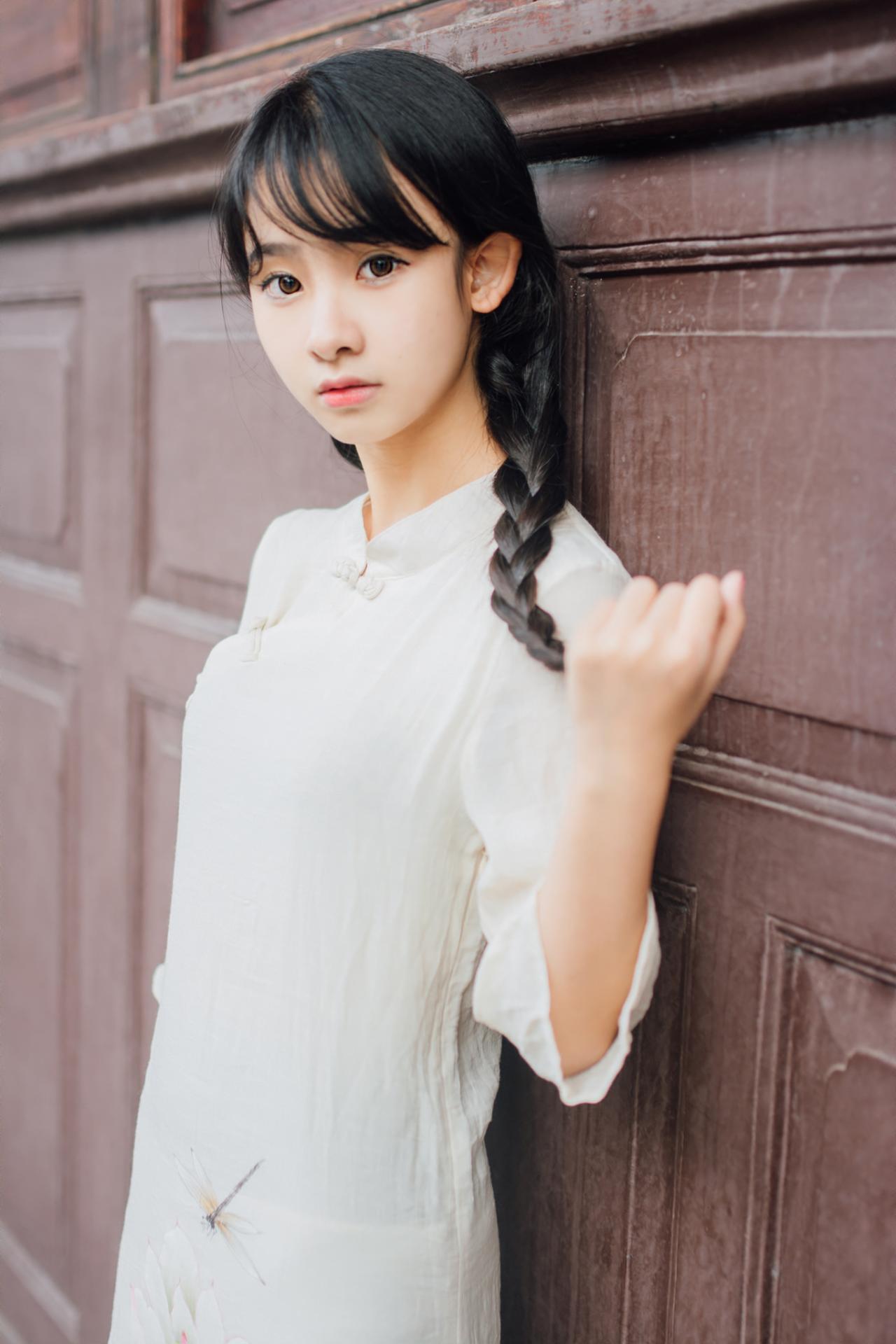 巫京蔓轻靠红木门侧面照