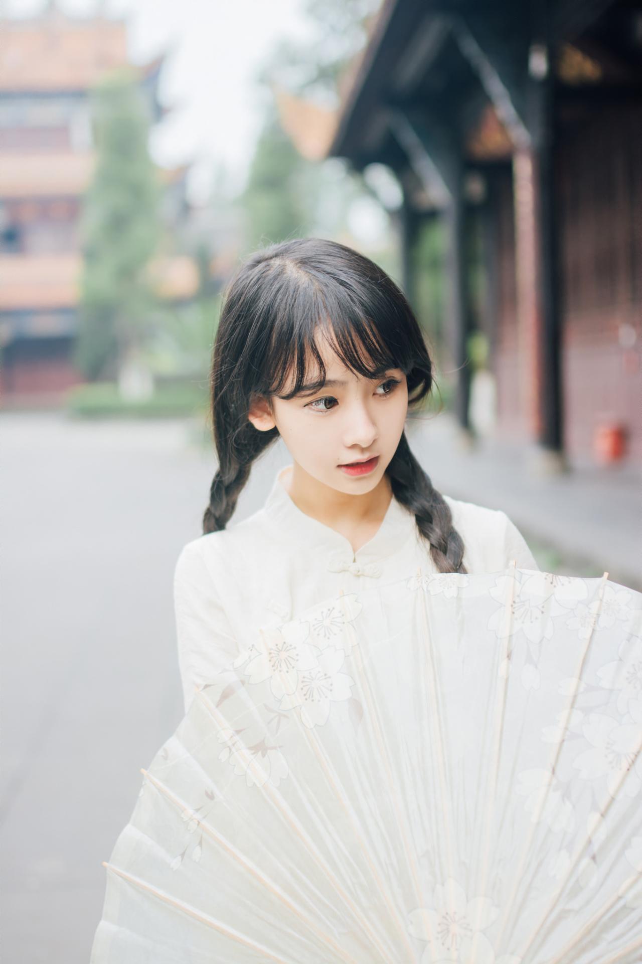 巫京蔓撑伞低头上半身照