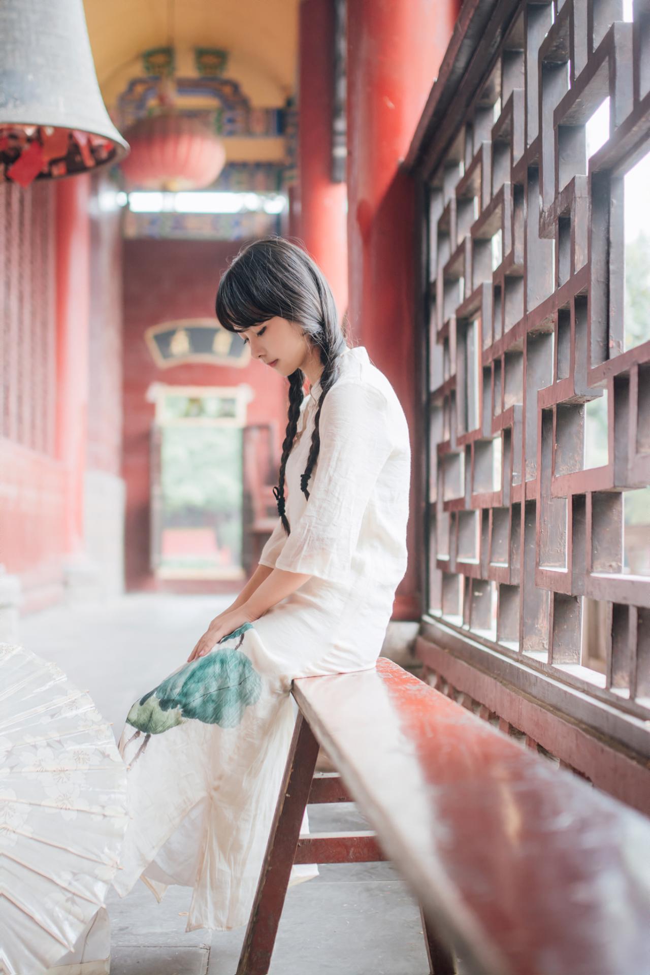 巫京蔓坐在红木椅上低头上半身照