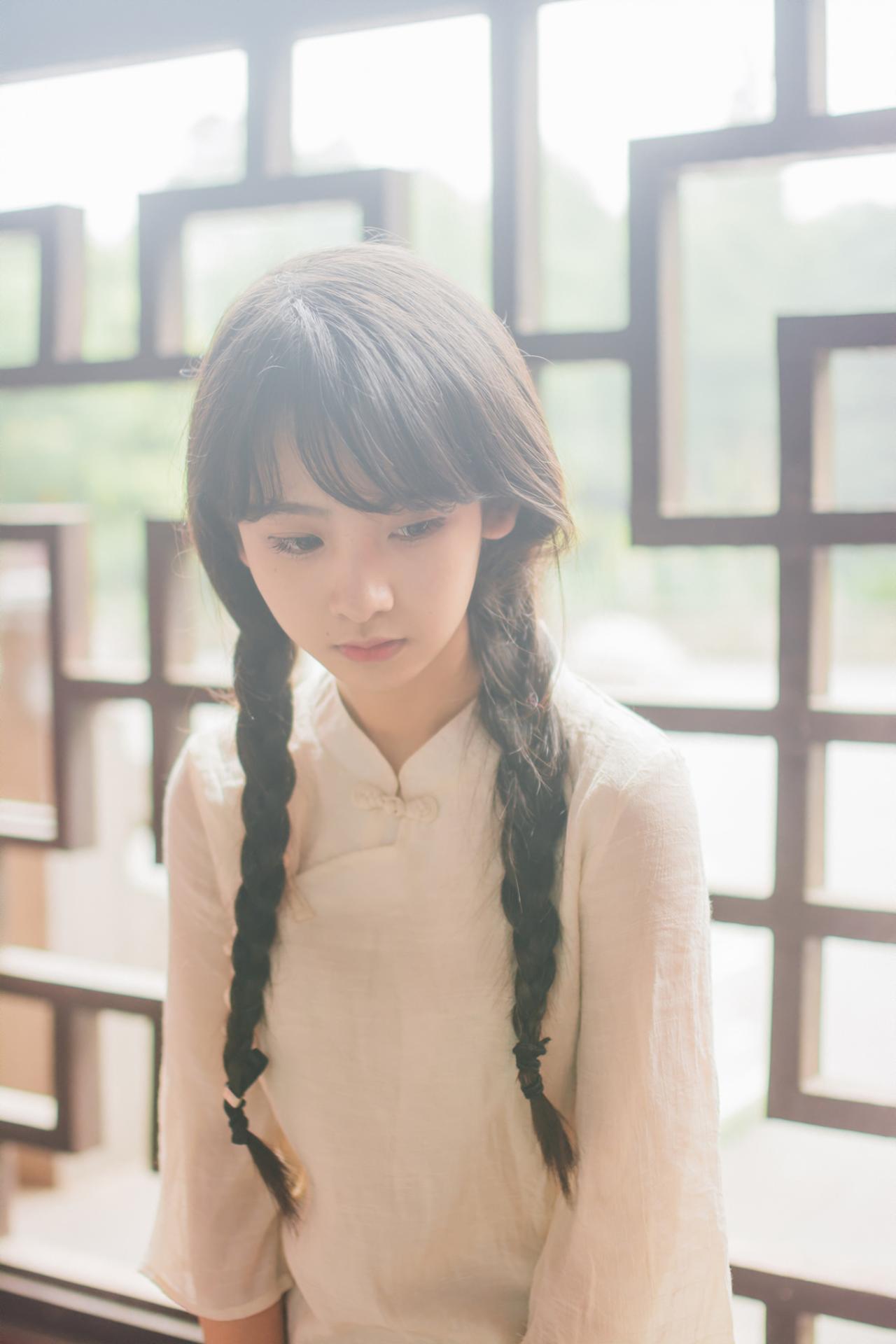 巫京蔓坐在红木椅低头上半身照