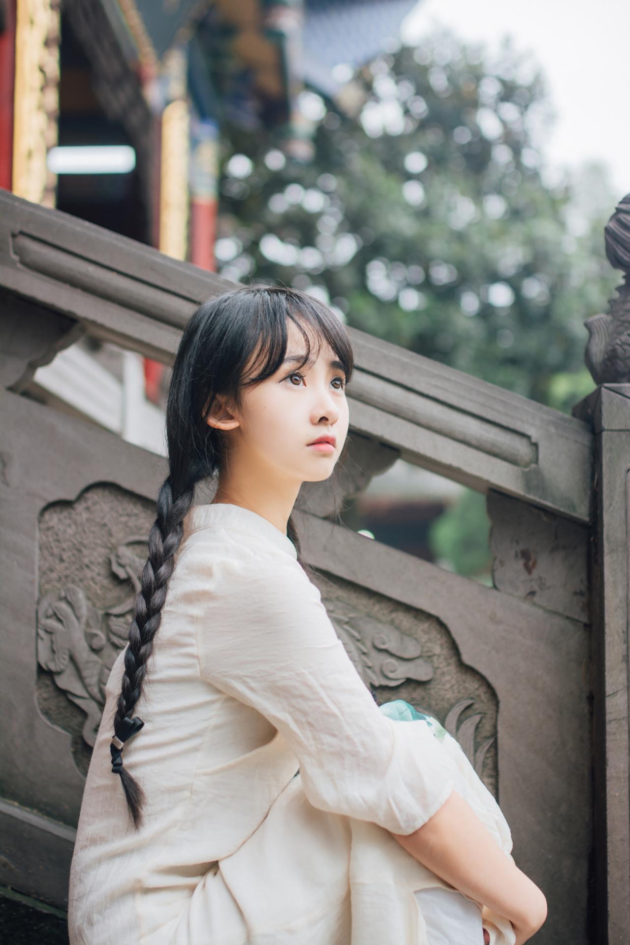 巫京蔓坐在青石台阶上上半身侧面照