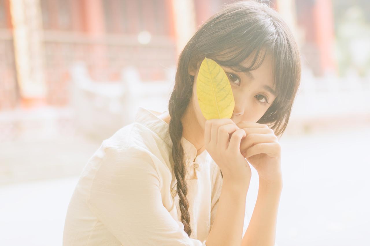 巫京蔓用树叶遮脸上半身照