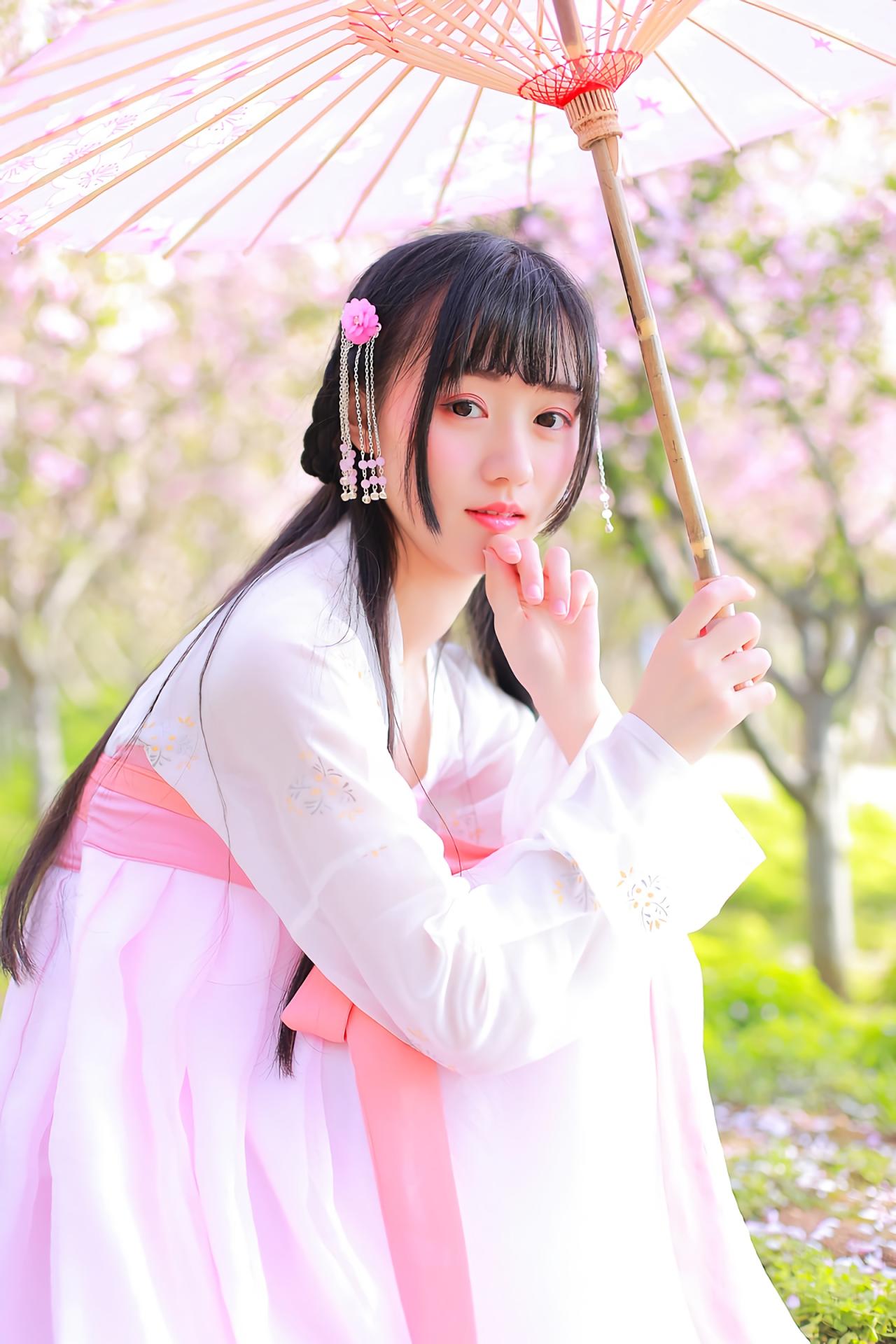 汤音璇撑伞蹲在草地侧面照