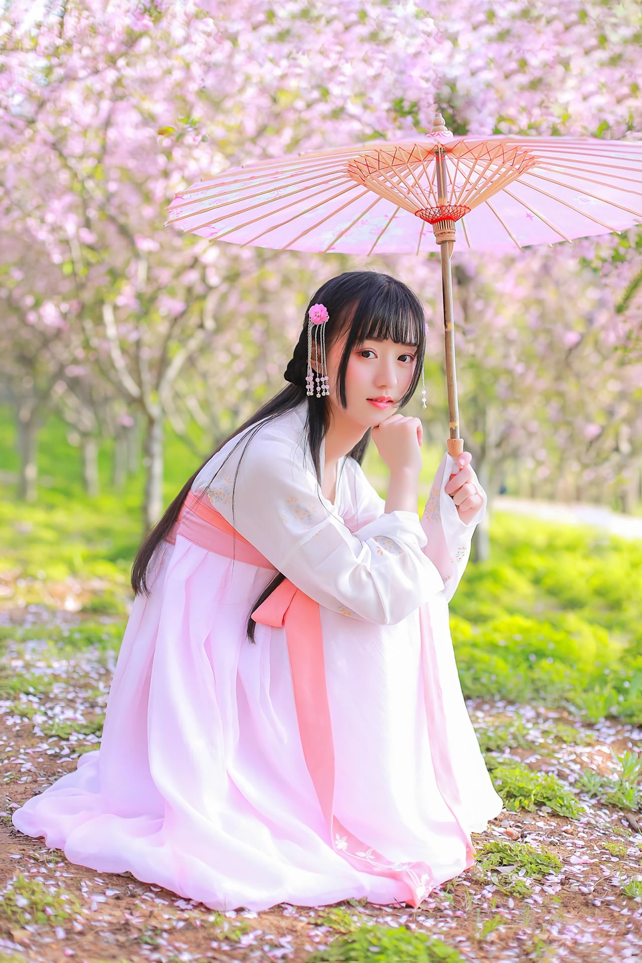 汤音璇蹲在草地撑伞侧面全身照