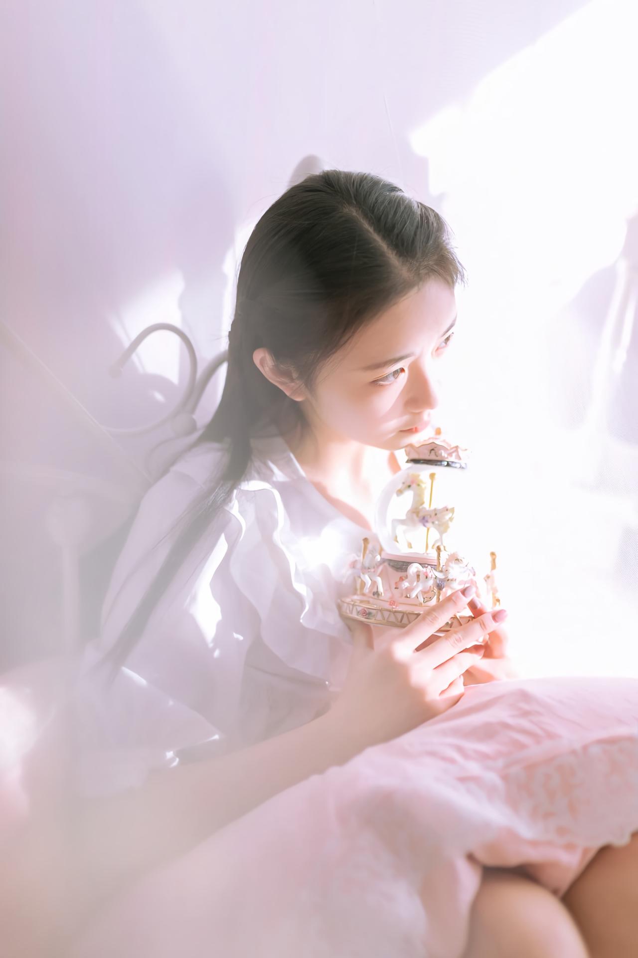 黑长直萌妹子双手捧着水晶球坐在床上