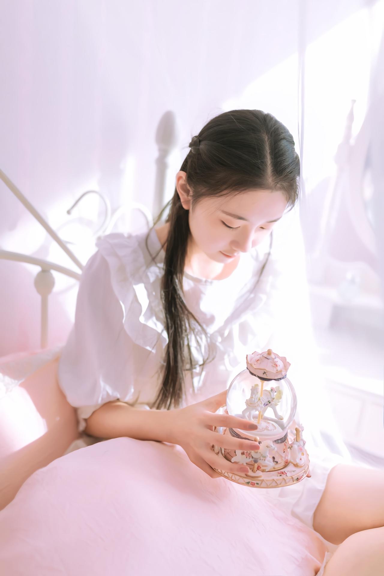 黑长直萌妹子坐在床上 双手捧着水晶球