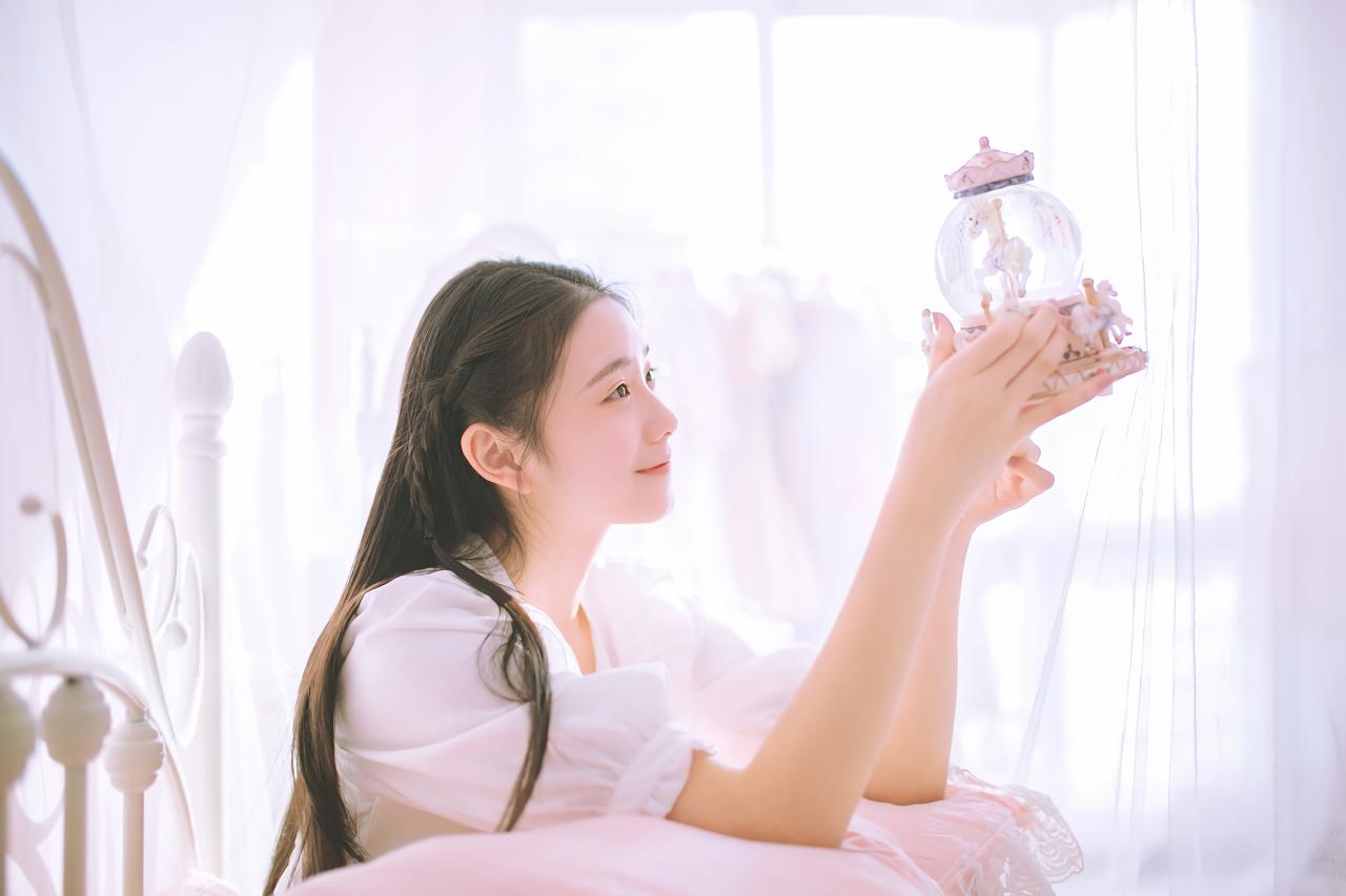 黑长直萌妹子双手捧着水晶球 双臂放在枕头上