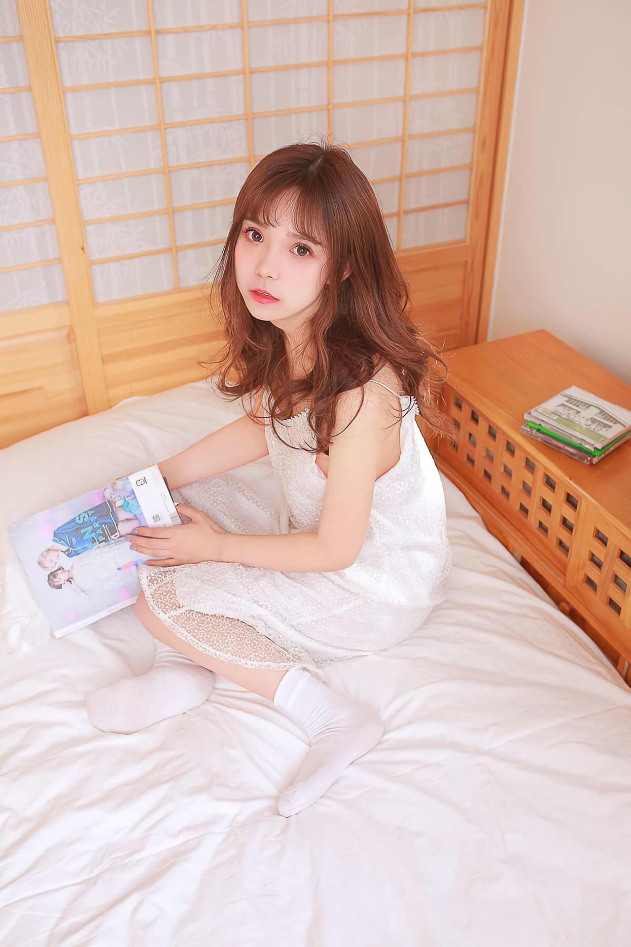 水蜜桃味的甜坐在床上看杂志