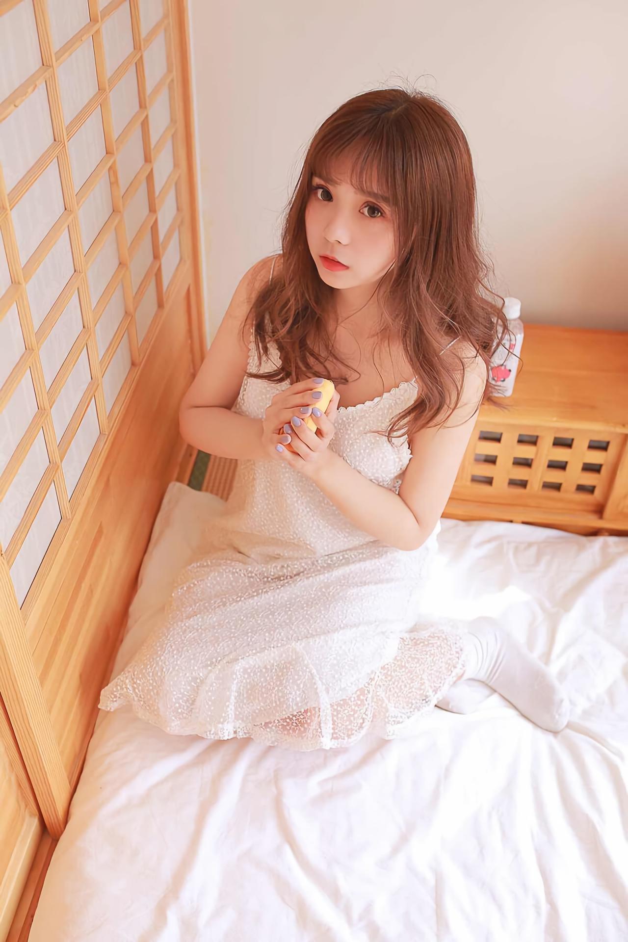 水蜜桃味的甜半跪在床上，双手捧着