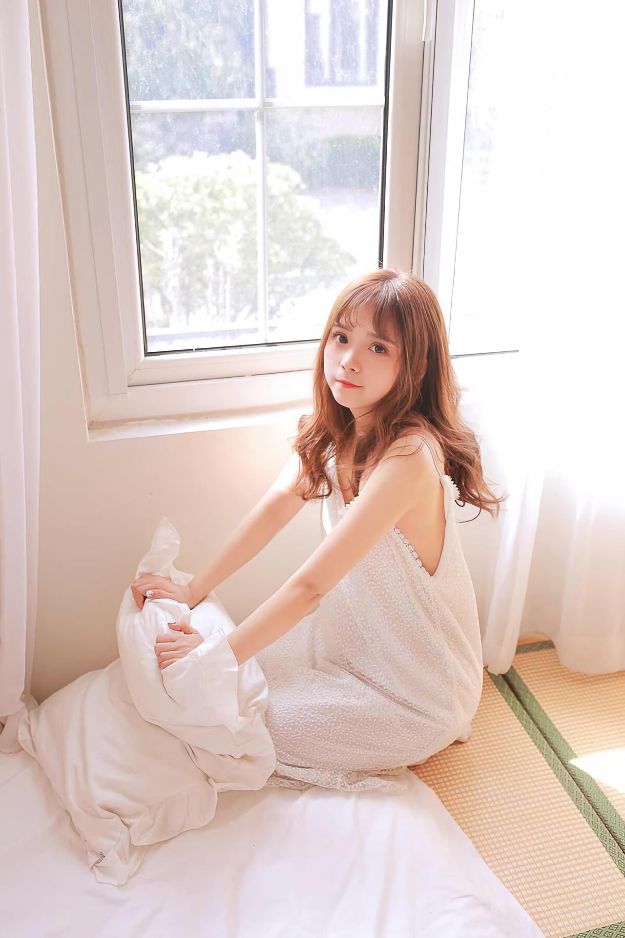 水蜜桃味的甜半跪在榻榻米上，双手撑在枕头上，全身照