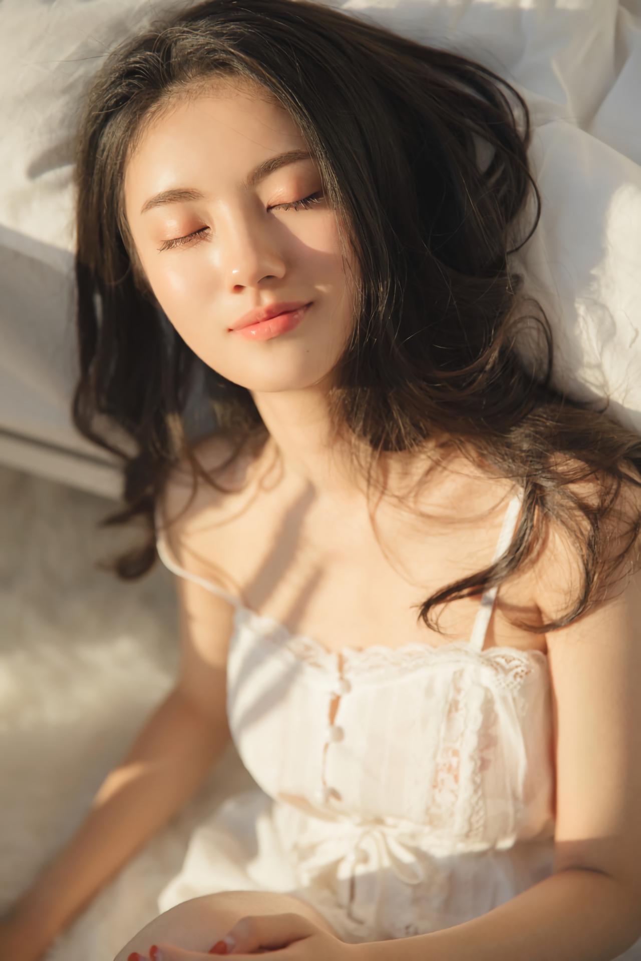 少女躺在床上，阳光洒在少女身上