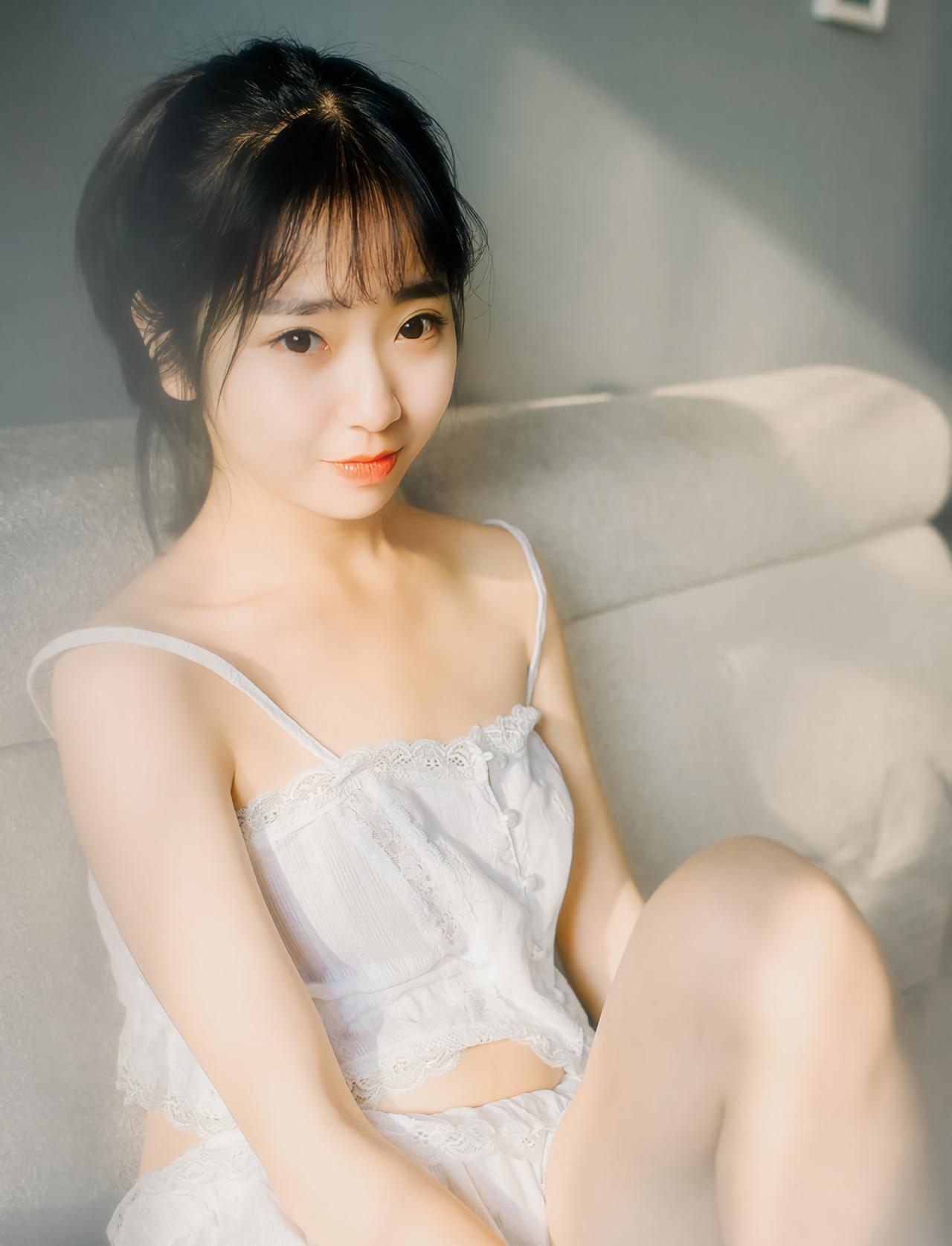 萌妹子坐在沙发上，3/4侧面