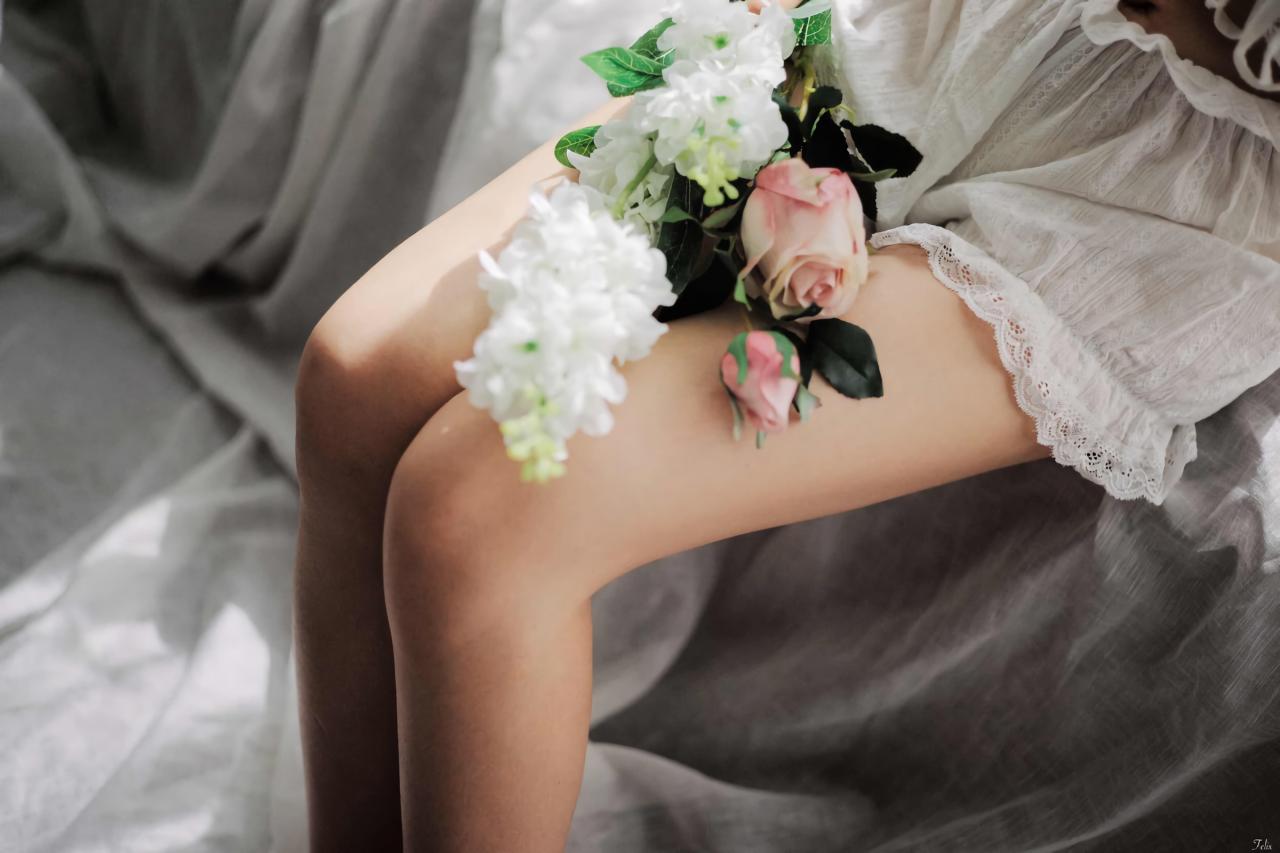 萌妹子靠在沙发上 白色窗帘盖在沙发上 手捧花放在双腿上