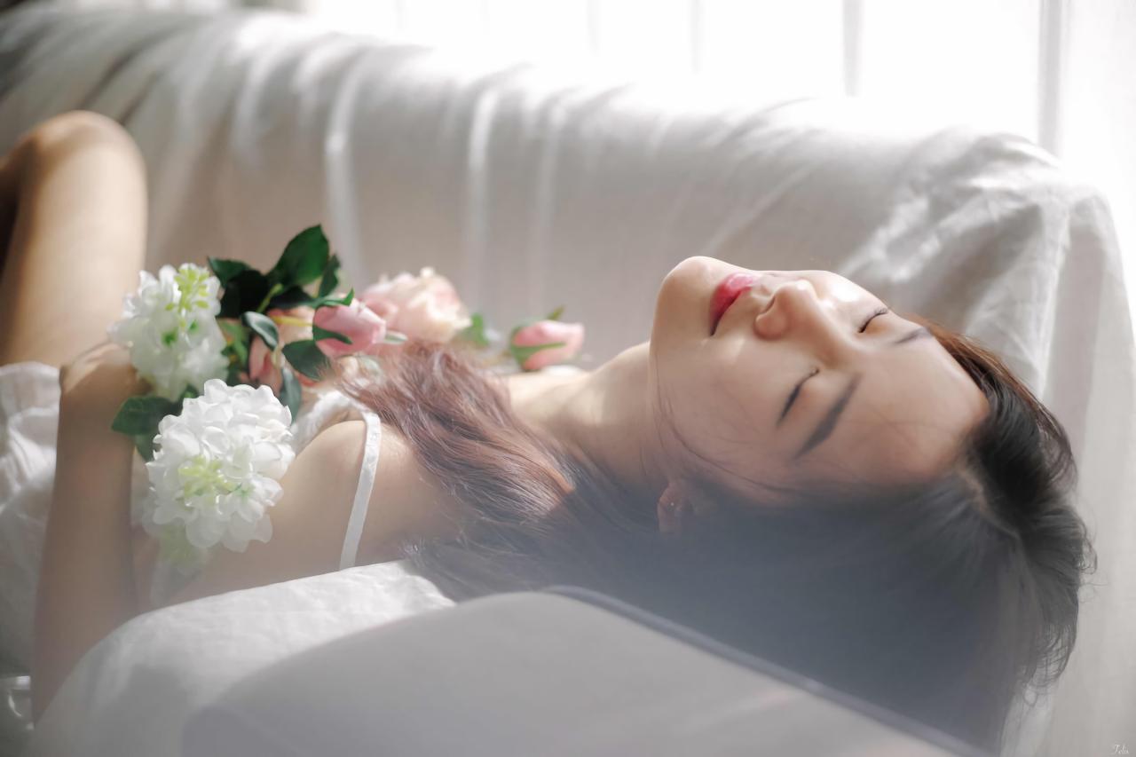 萌妹子闭着眼睛躺在沙发上 白色窗帘盖在沙发上 双手捧着手捧花
