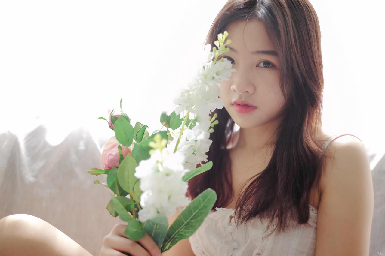 萌妹子靠在沙发上 白色窗帘盖在沙发上 握着手捧花 上半身正面照