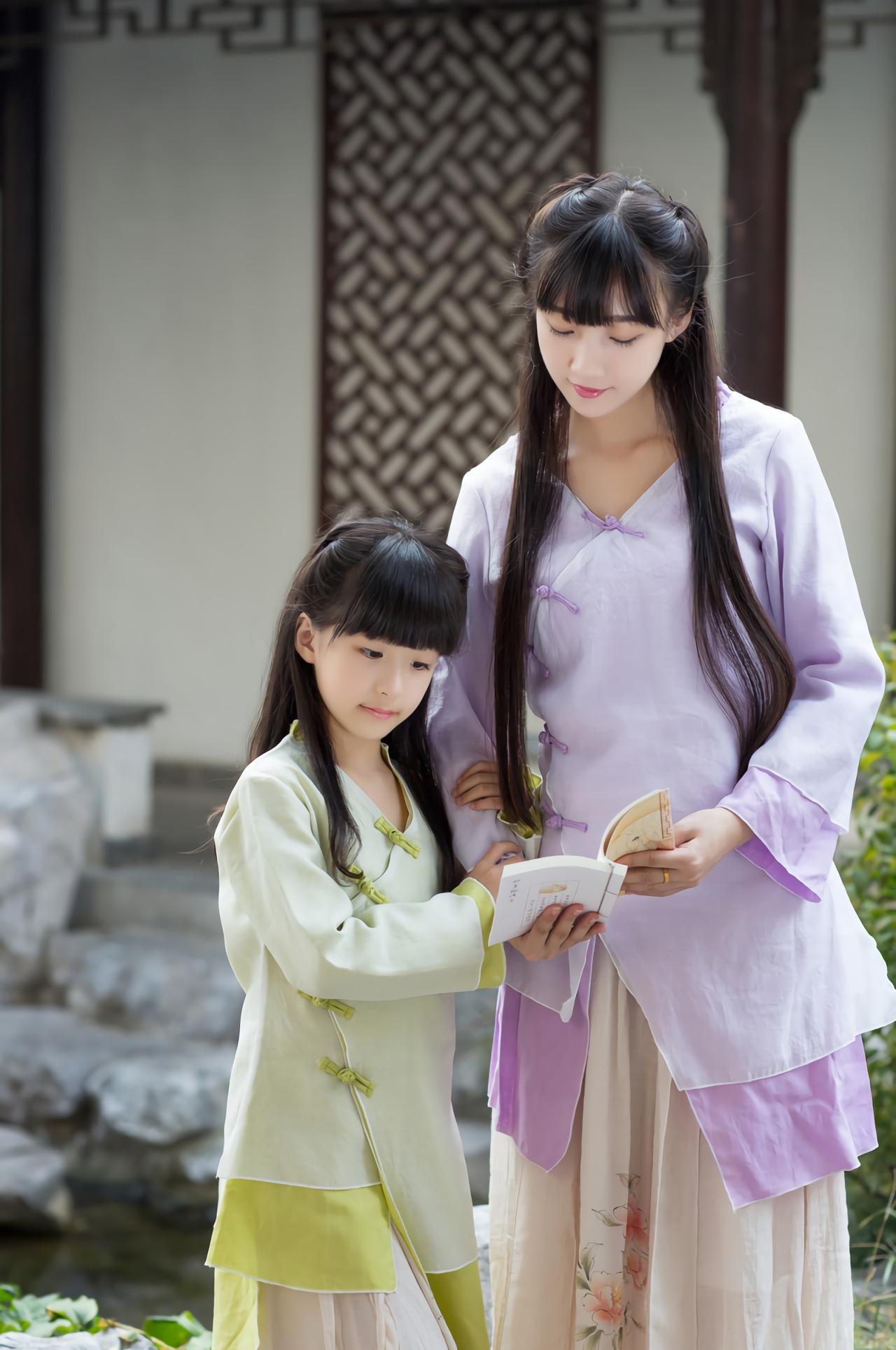 大乔和小乔双手捧着书 站在池塘旁