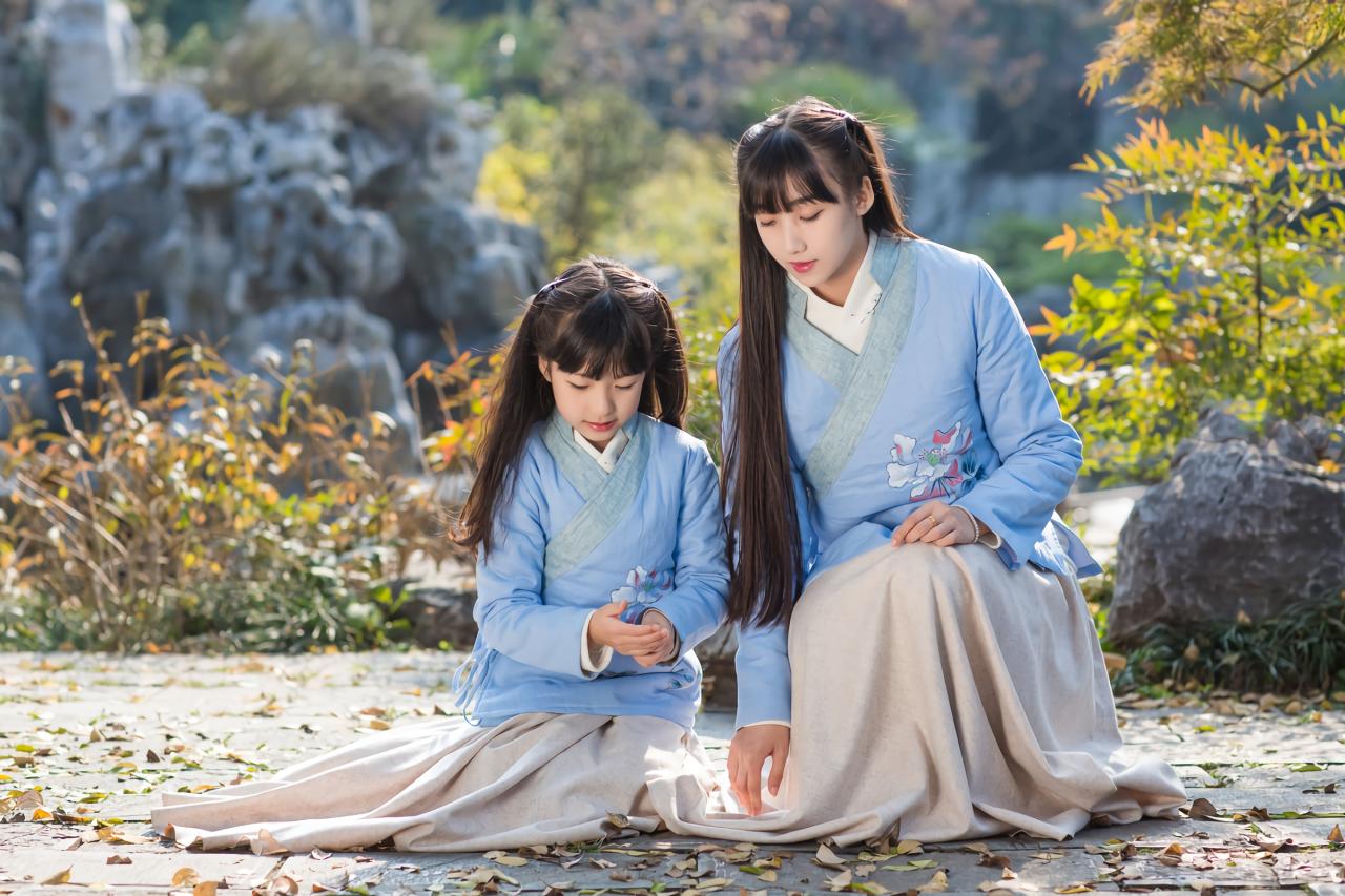 大乔和小乔盘坐在铺着落叶的地板上