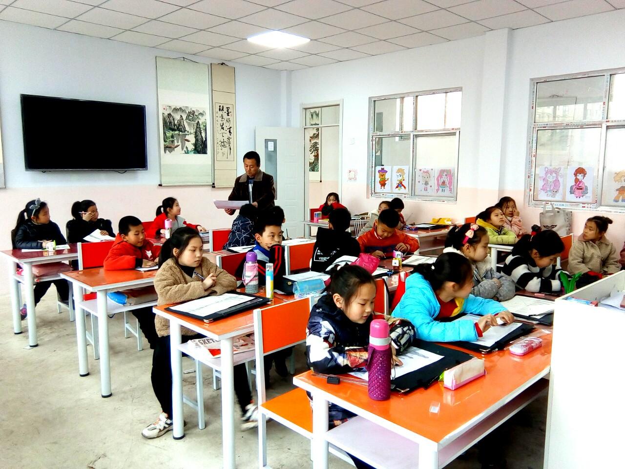 老师正在辅导一部初级班的学生的课堂作业