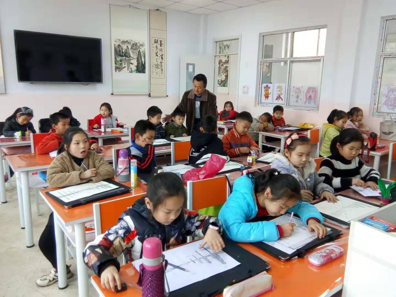 老师正在辅导一部初级班的学生的课堂作业