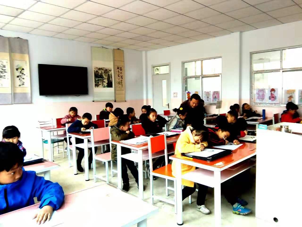 老师正在给圆梦画室一部初小班辅导绘画