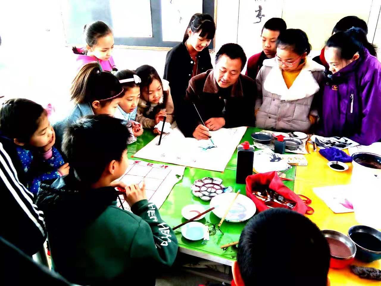 圆梦画室国画二班正围绕在老师身边，听老师讲解写意画