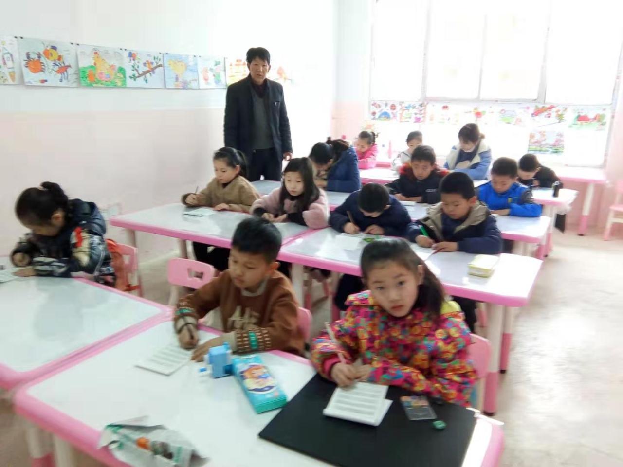 老师正在给圆梦画室硬笔书法一班的学生辅导课堂作业